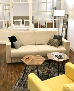 a living room with a couch and two tables at Magnifiques Appartements Hyper Centre in Nantes