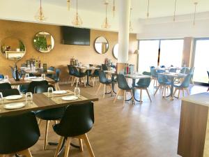 a dining room with tables and chairs and windows at SR Palmela Village Studios II in Quinta do Anjo