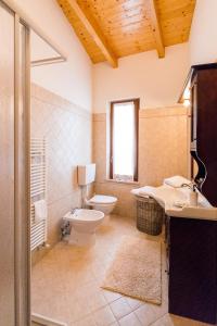 uma casa de banho com um WC e um lavatório em Domus Amica em Lu