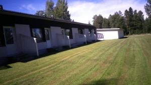 a building with a large grass field in front of it at Karijoen Helmi in Karijoki