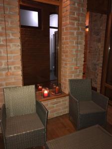 eine Terrasse mit 2 Stühlen und einem Kamin mit 2 Kerzen in der Unterkunft Inka home in Bordschomi