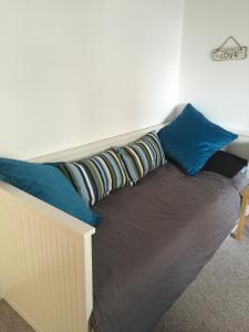 a bed with blue pillows on top of it at Troon Beachcombers in Troon