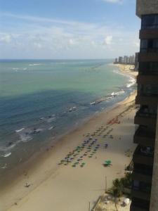 eine Luftansicht auf einen Strand mit Sonnenschirmen und dem Meer in der Unterkunft Apartamento 3 quartos em frente ao Mar in Recife