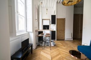 a living room with a kitchen with a bar and stools at Doyenné Vieux Lyon in Lyon
