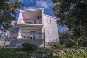 a large white house with a balcony at Apartments Mama in Rogoznica
