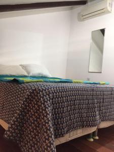 ein Bett mit einer Decke auf dem Zimmer in der Unterkunft Apartamento Taíba Beach Resort in Taíba