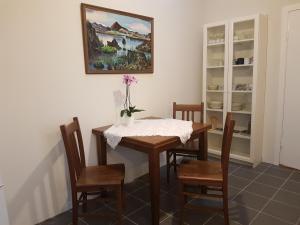 uma sala de jantar com uma mesa e cadeiras e um quadro em Vorsabær Apartment em Selfoss
