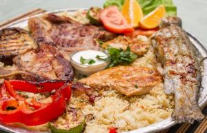 a plate of food with meat and rice and vegetables at Eco village Raj u raju in Konjic +79 photos