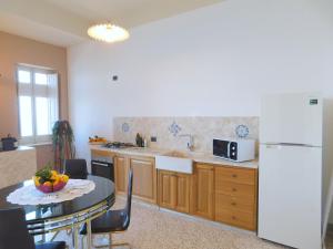 特拉帕尼的住宿－Appartamento Belvedere，厨房配有桌子和白色冰箱。