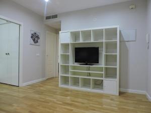 un centro de entretenimiento blanco con TV en una habitación en Apartamentos Bahía, en El Puerto de Santa María