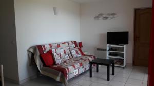 sala de estar con sofá y TV en Vue mer Corse, en Conca