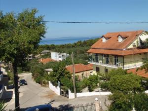 a house with a red roof and a street with a car at Villa Nefeli in Loutsa