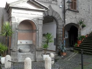 ein Gebäude mit einem steinernen Torbogen mit Topfpflanzen in der Unterkunft La casa della nonna sulla francigena in Campagnano di Roma