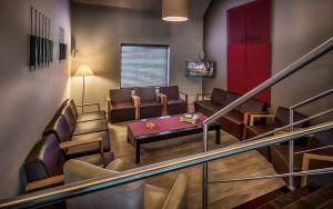 a living room with chairs and a table and a staircase at Cleythil Hotel in Maldegem