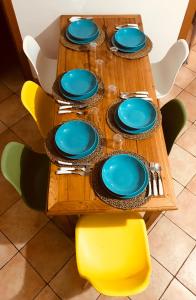 une table en bois avec des plaques et des chaises bleues dans l'établissement Fisherman House - Sorrento Coast, à Sorrente