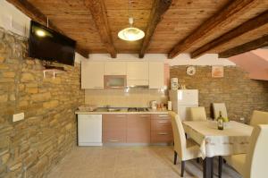 eine Küche mit einem Tisch und einem TV an der Wand in der Unterkunft Holiday House Eda with Private Pool in Buzet