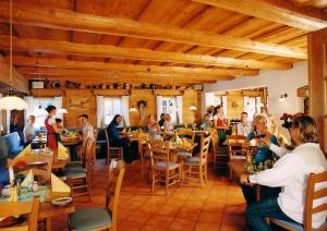 Landhotel Quirle-Häusl في ترسدورف: مجموعة من الناس يجلسون على الطاولات في المطعم