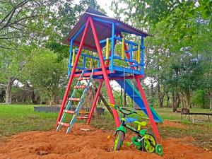 a playground with a ladder and a bike in the dirt at Hotel Comodoro De Quaraí in Quaraí