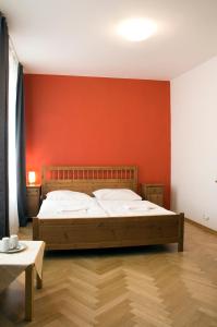 um quarto com uma cama grande e uma parede vermelha em Ai Quattro Angeli em Praga