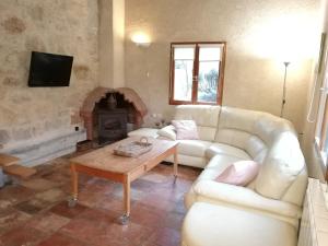 sala de estar con sofá blanco y chimenea en Gite au Lac du Gouyre, en Puygaillard-de-Quercy