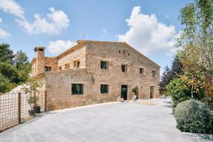 an external view of a stone house with a driveway at Vila Caelus masía boutique in Rubio