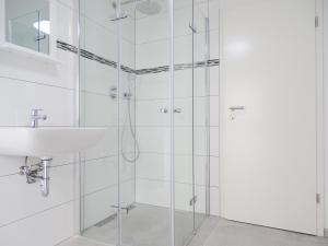 a bathroom with a glass shower with a sink at AVI City Apartments KingHouse in Düsseldorf