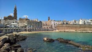 a body of water with some rocks and buildings at Il Porto Di Ciccia' in Monopoli