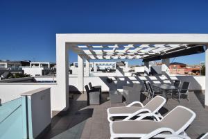 オリフエラ・コスタにあるPenthouse Oasis Beach VI La Zeniaのパティオ(白い椅子、屋上テーブル付)