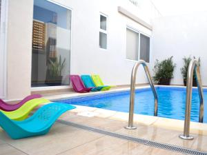 a pool with colorful chairs next to a swimming pool at 8villa in St. Julianʼs