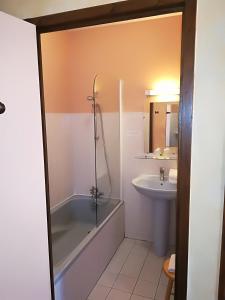 ein Bad mit einer Dusche und einem Waschbecken in der Unterkunft Hostellerie Saint Martin- Logis Hôtel et Restaurant in Creully