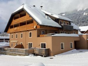 dom ze śniegiem na dachu w obiekcie Obersdorfer Hof w mieście Bad Mitterndorf