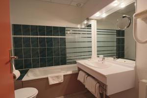 Logis-Hôtel des Oliviers في تيونفيل: حمام مع حوض وحوض استحمام ومرحاض