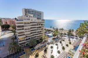 マルベーリャにあるApartamento Marbella Playa Centroのヤシの木と海の浜辺の建物