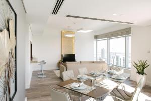 a living room with a table, chairs, and a large window at Boutique Living - Burj Views Downtown Dubai in Dubai