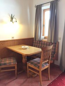 a wooden table and two chairs with a table and a window at Gästehaus Tanneck in Reit im Winkl