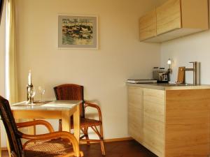 eine Küche mit einem Tisch, 2 Stühlen und einer Theke in der Unterkunft Hotel Enddorn Appartement in Grieben