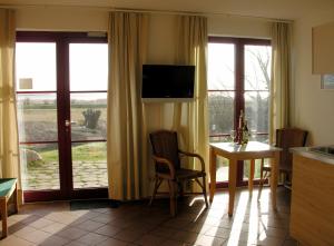 cocina con mesa, sillas y ventana en Hotel Enddorn Appartement en Grieben