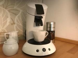 a coffee maker with a cup on top of it at SEASIDE APARTMENTS - SANDY GOLD in Eckernförde