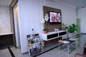 ein Wohnzimmer mit einem TV an der Wand in der Unterkunft Palace Hotel Guaíra in Guaíra