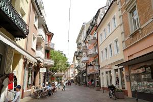 a city street with people sitting at tables and buildings at Apartment Baden-Baden Altstadt Zentrum in Baden-Baden