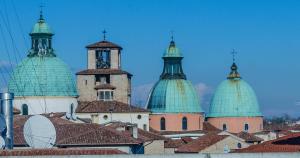 eine Gruppe von Kuppeln auf einem Gebäude mit Dächern in der Unterkunft Appartamento Alloro in Treviso