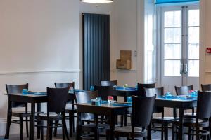a dining room with tables and chairs with cakes on them at Carlton Hotel in Ilfracombe