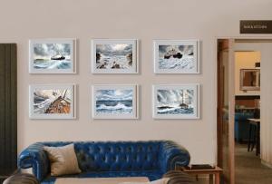 a blue couch in a living room with pictures on a wall at Carlton Hotel in Ilfracombe