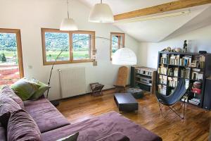 a living room with a couch and a book shelf at Le Mont Fleuri Saint Gervais Les Bains in Saint-Gervais-les-Bains