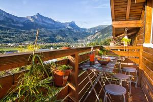een balkon met een tafel en stoelen en bergen bij Le Mont Fleuri Saint Gervais Les Bains in Saint-Gervais-les-Bains