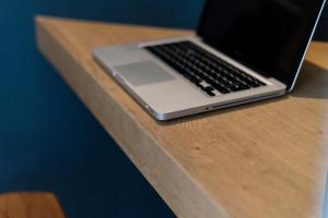 einen Laptop auf einem Holztisch in der Unterkunft Doyenné Vieux Lyon in Lyon
