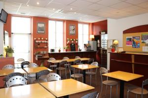 
a classroom with tables, chairs, and tables in it at Logis-Hôtel des Oliviers in Thionville
