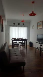 sala de estar con mesa, sillas y sofá en Departamento Alsina en Salta