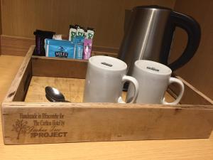 a wooden box with two mugs and a mouse at Carlton Hotel in Ilfracombe