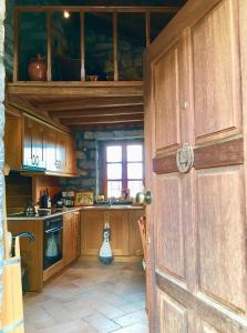 a kitchen with a wooden door and a window at Anna Vytina in Vitina